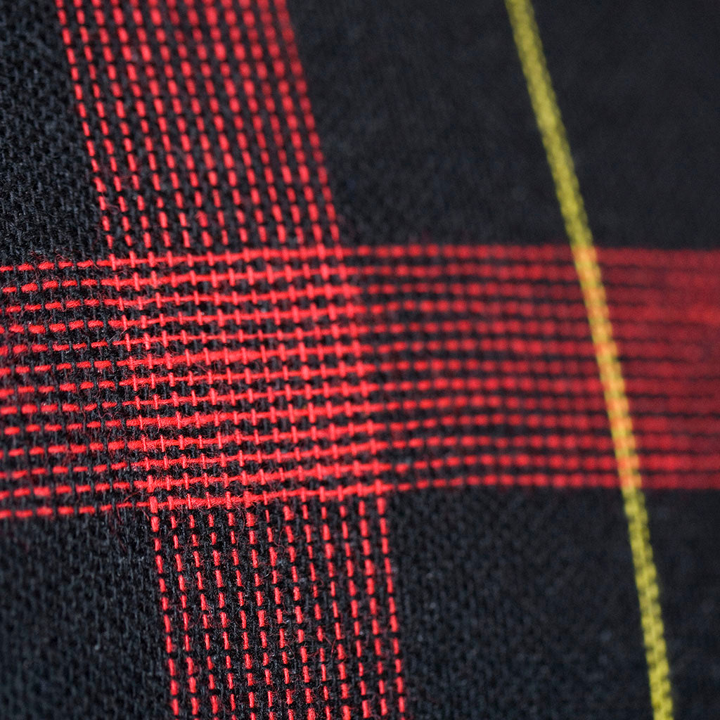Close-up of vintage navy wool tartan fabric detail highlighting rich texture and subtle color variations in the cushion's