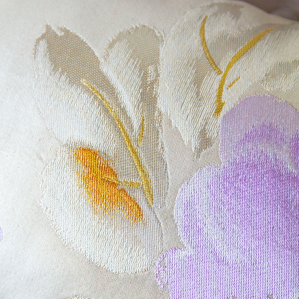 Close up of camilla flower obi silk in cream, lilac and gold.