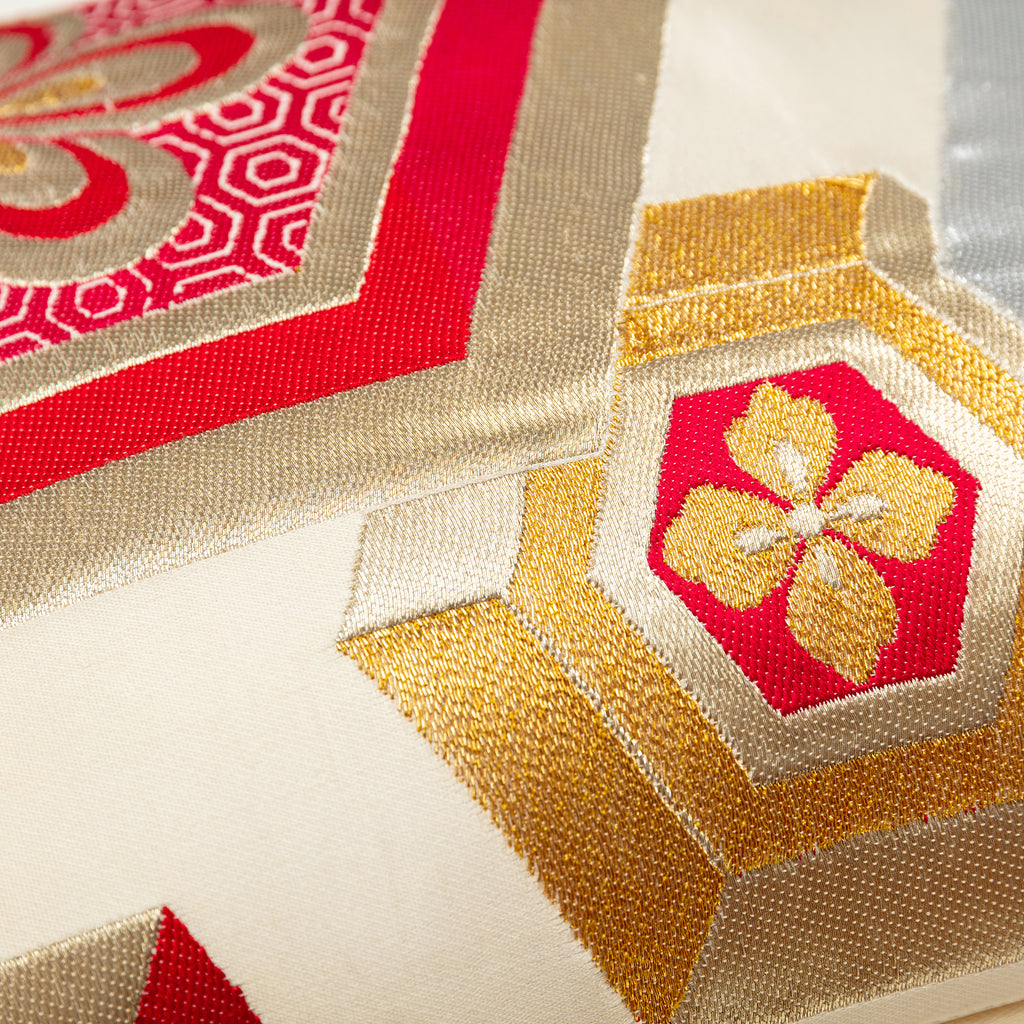 Close up detail of the gilt thread woven hexagons pattern on a vintage silk obi pillow.