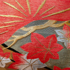 Close-up of peach velvet fabric with pines embroidery on the black obi pillow's corner, highlighting detailed stitching and