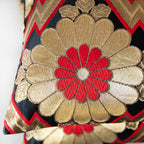 Detail of a gold and red chrysanthemum symbol on a black vintage silk obi cushion.