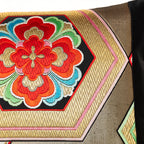 Deatil of a vintage Japanese silk obi cushion in metallic gold with red flowers and pink edged hexagons.