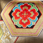 Detail of a red hanabishi floral motif on a vintage silk cushion in gold.