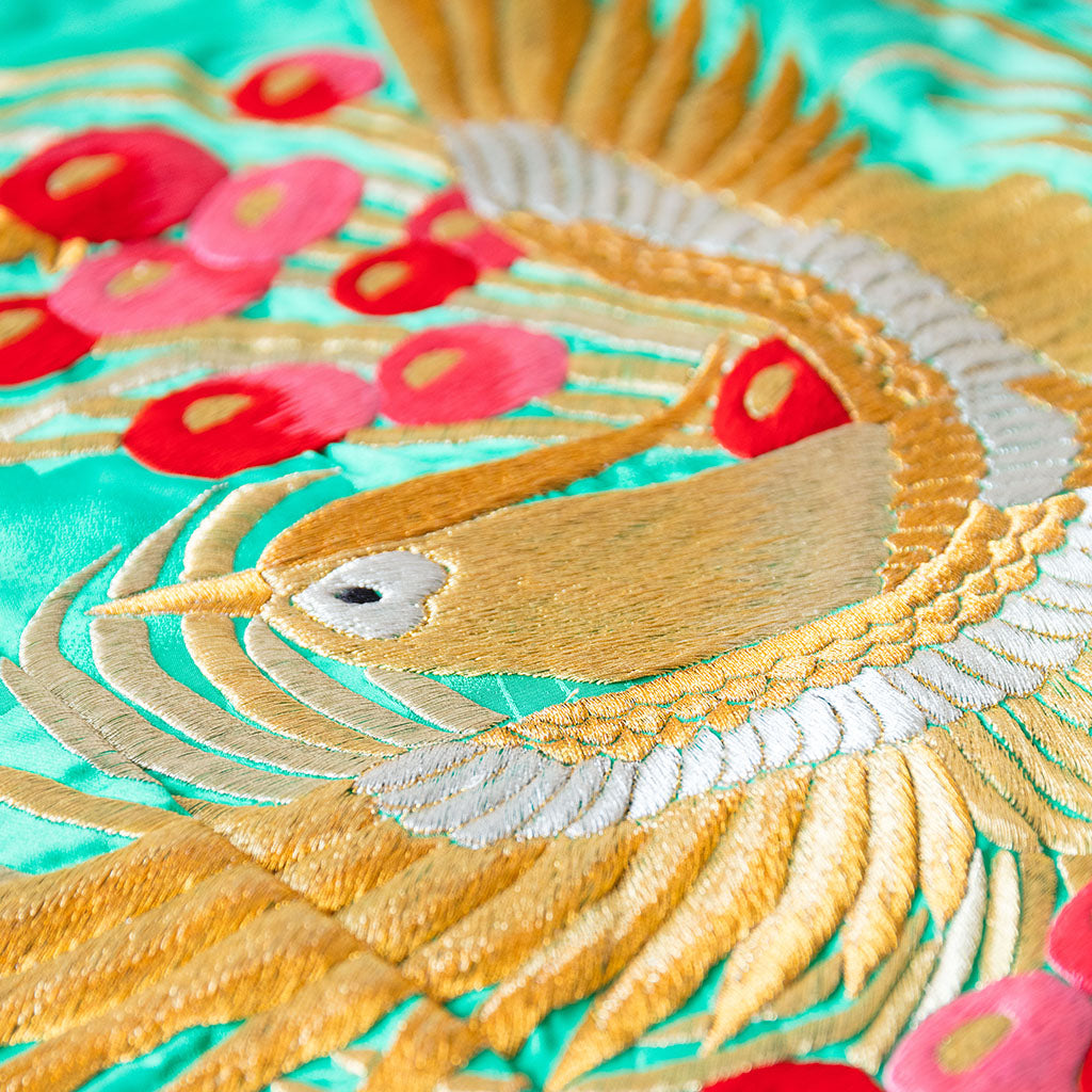 Close-up of intricate phoenix embroidery and shimmering gold silk fabric showcasing vintage wedding kimono-inspired quilting