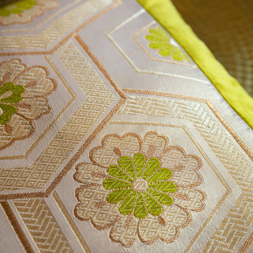 Close-up of gold hexagon with green flower motif, on a vintage Japanese obi silk cushion, 19 inches square.