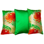 Close-up of red floral silk obi cushion fabric's intricate embroidery and glossy silk texture from a diagonal angle.