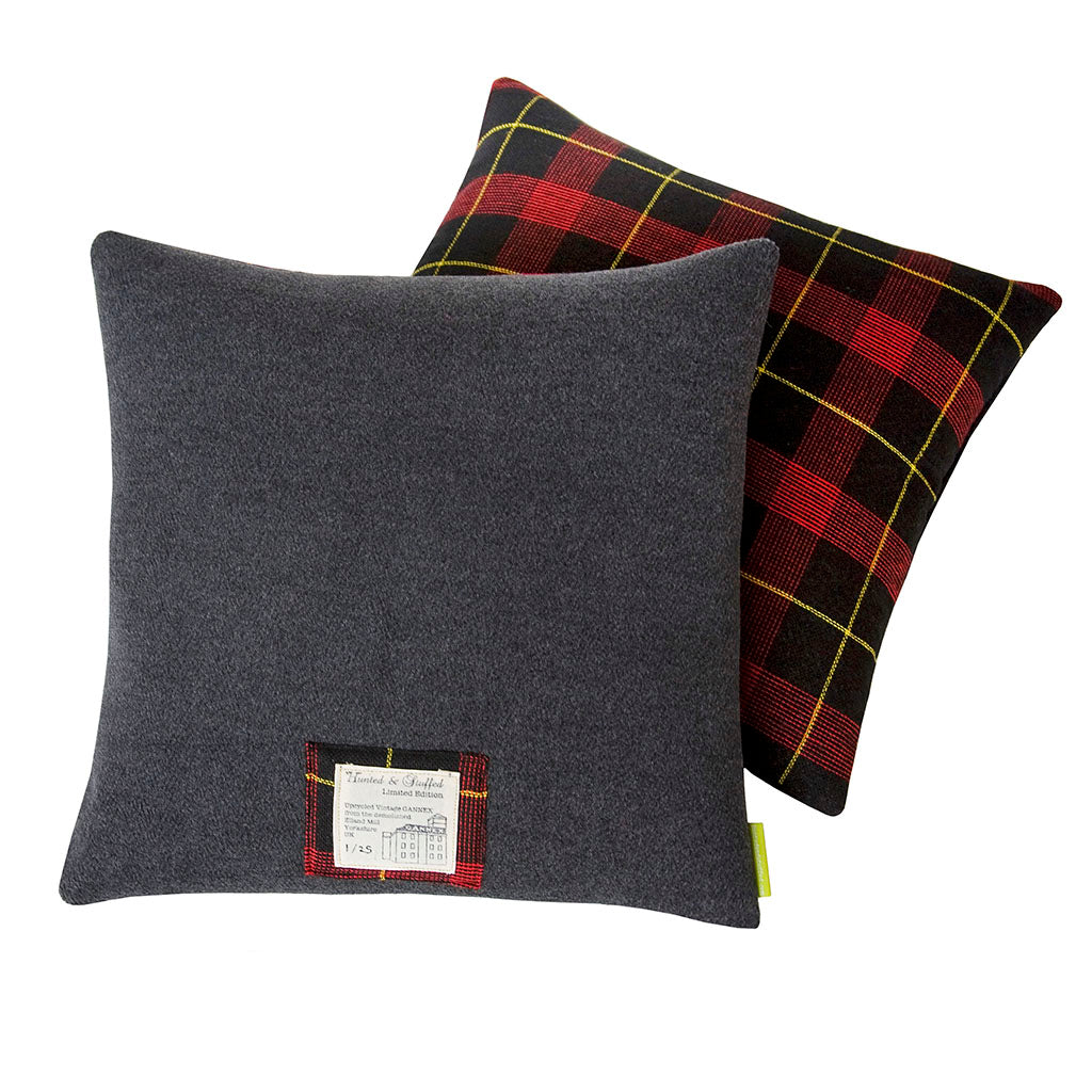 Close-up of grey tartan wool fabric highlighting textured weave and subtle color variations at a slight angle.