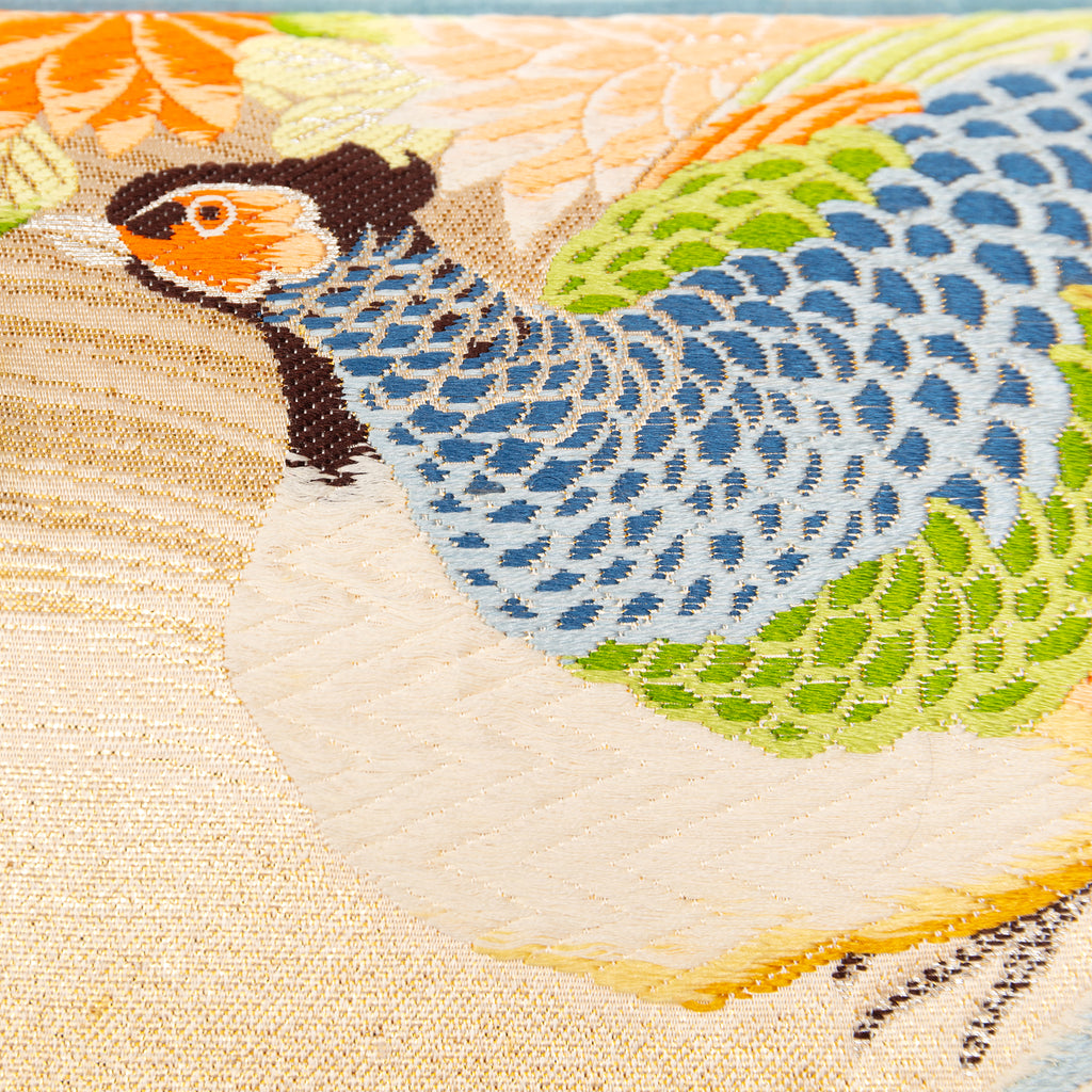 Close-up of cream Maru Obi silk embroidery detail on the pillow's corner, highlighting intricate stitching and luxurious