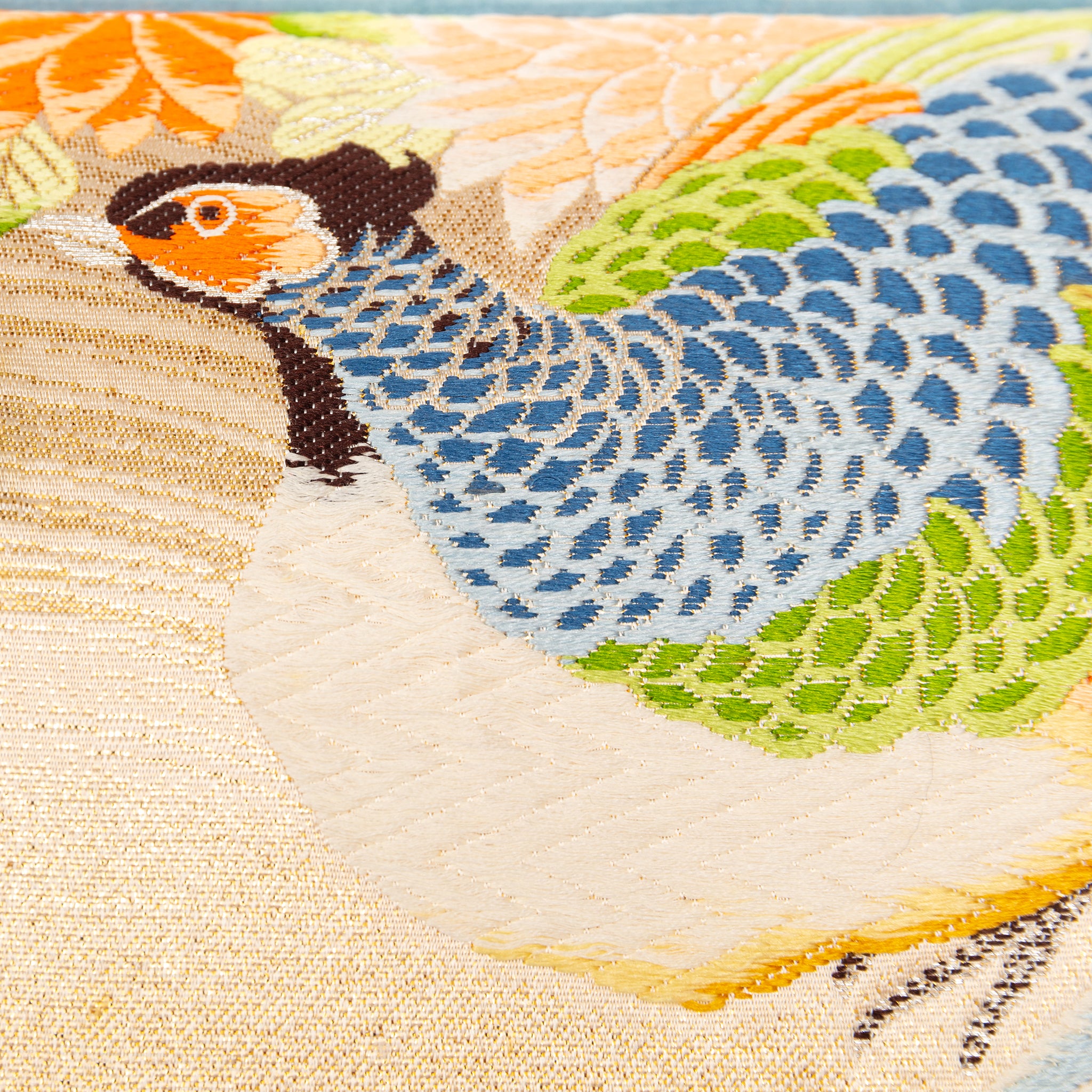 Close-up of cream Maru Obi silk embroidery detail on the pillow's corner, highlighting intricate stitching and luxurious