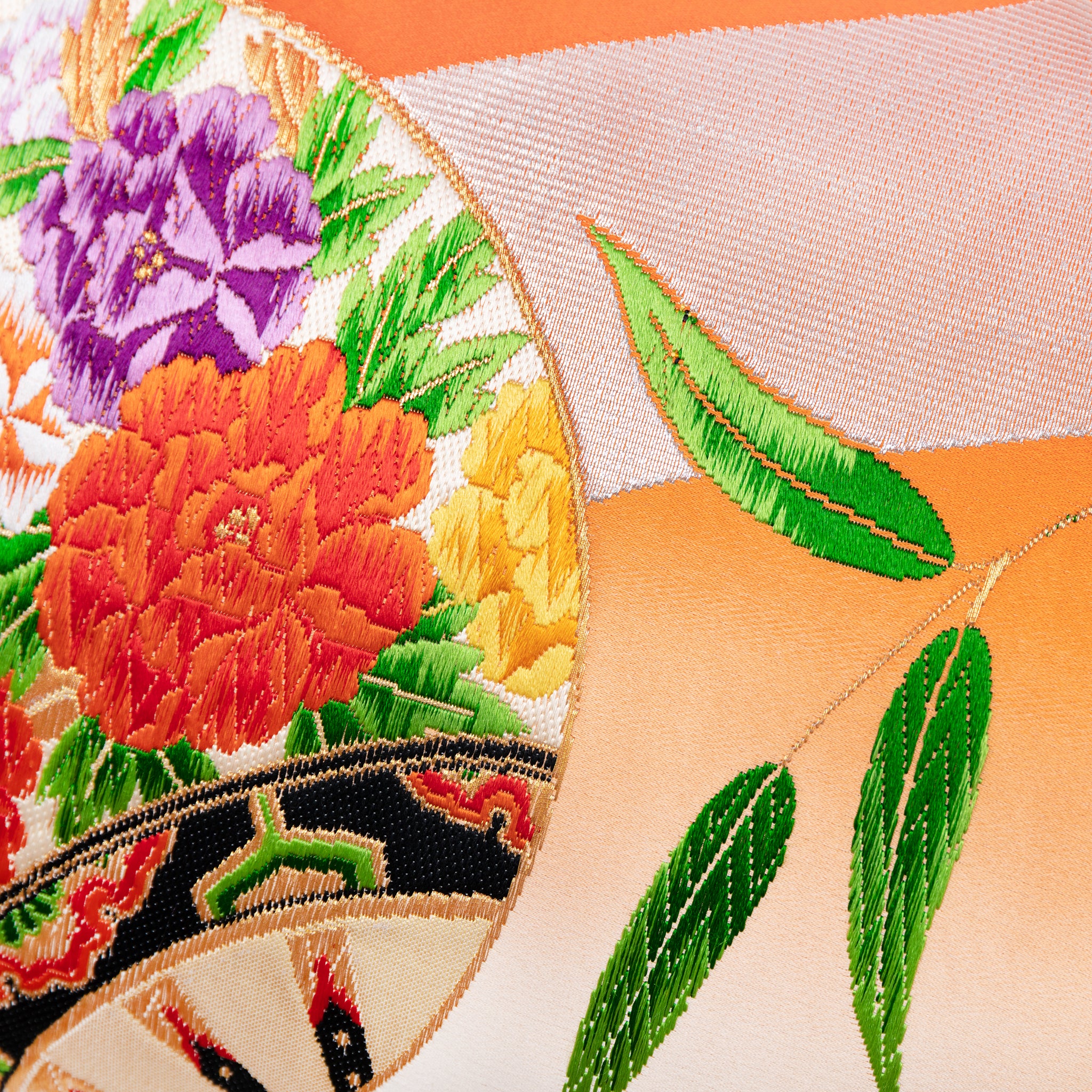 Close-up of the vibrant orange ombre silk fabric highlighting its smooth, lustrous texture and subtle silver bamboo