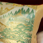 Close-up of the vibrant Nishijin kimono silk fabric featuring intricate mountain temple motifs with a velvet back edge and