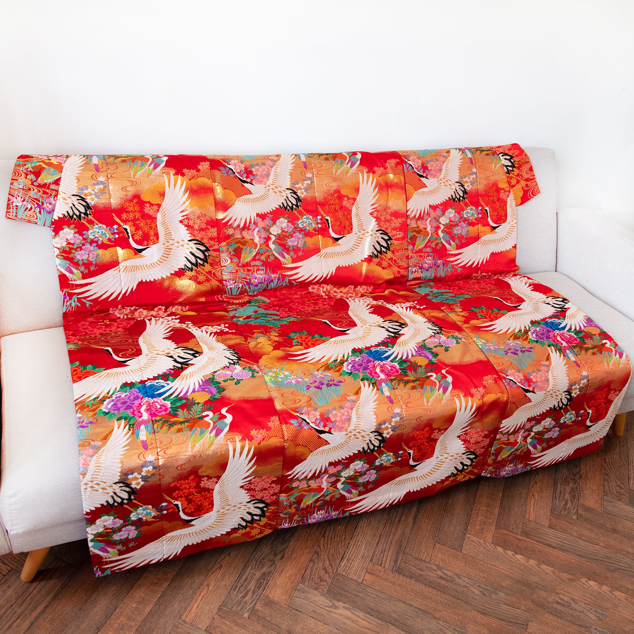 silk throw made from vintage kimono silk in red with white cranes on a sofa