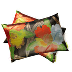 Pile of metallic vintage Japanese obi cushions with colourful camellia flowers and gold leaves.