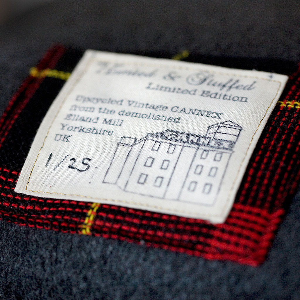 Close-up of grey tartan wool fabric highlighting textured weave and subtle color variations of the Gannnex vintage cushion