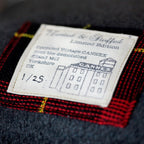 Close-up of grey tartan wool fabric highlighting textured weave and subtle color variations of the Gannnex vintage cushion