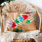 Gold Japanese obi cushion with feather design on a cane chair.