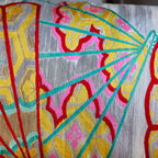 Close up detail of japanese bolster cushion made with 1950s silver maru obi with colourful fan designs.