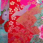 Close-up of the intricate pink crane embroidery on the velvet edge, highlighting fine stitching and rich color contrast.