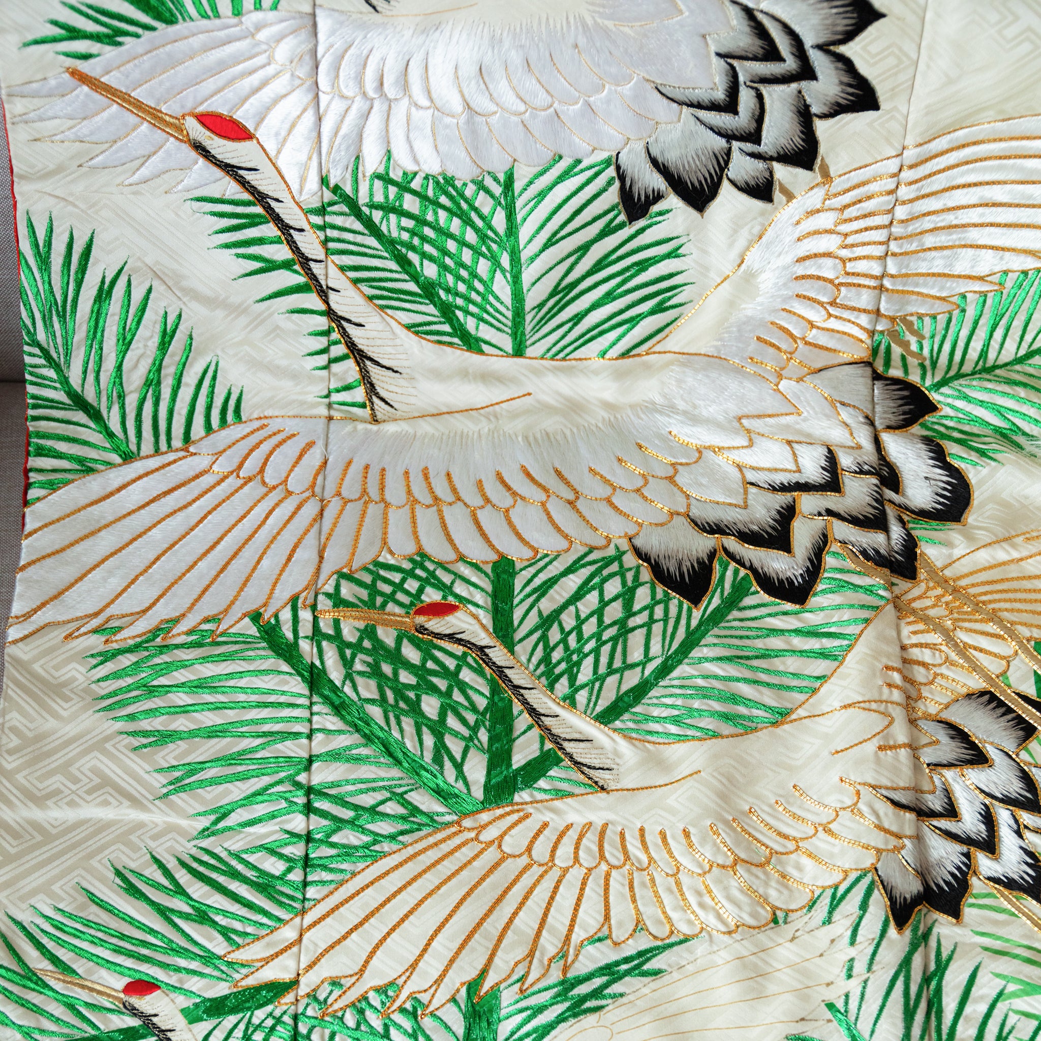 close up of silk throw made from vintage kimono silk, green pines on white with flying cranes.