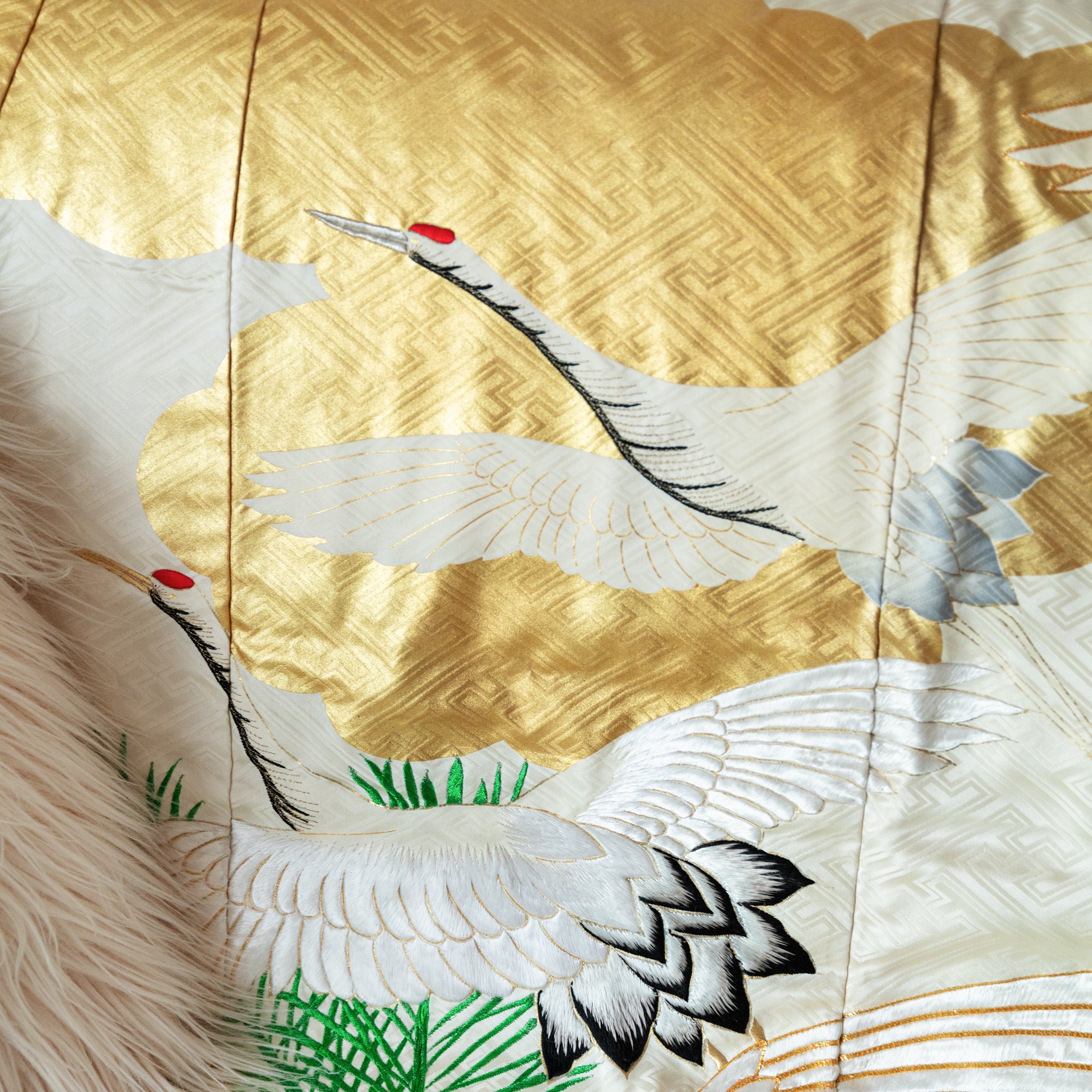 close up of vintage kimono silk throw with gold clouds and white flying cranes