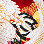Close-up of the embroidered red silk floral pattern on black velvet, highlighting intricate stitching and textured surface.
