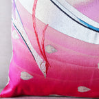 Close-up of silver peacock feather embroidery detail on the pink silk obi cushion’s corner.