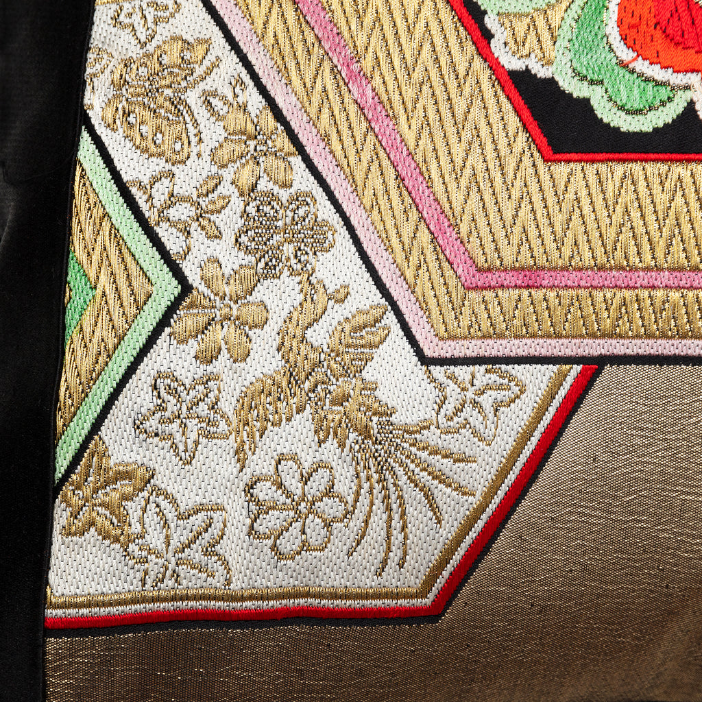 Close up of a phoenix motif in gold on a vintage obi cushion.