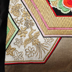 Close up of a phoenix motif in gold on a vintage obi cushion.