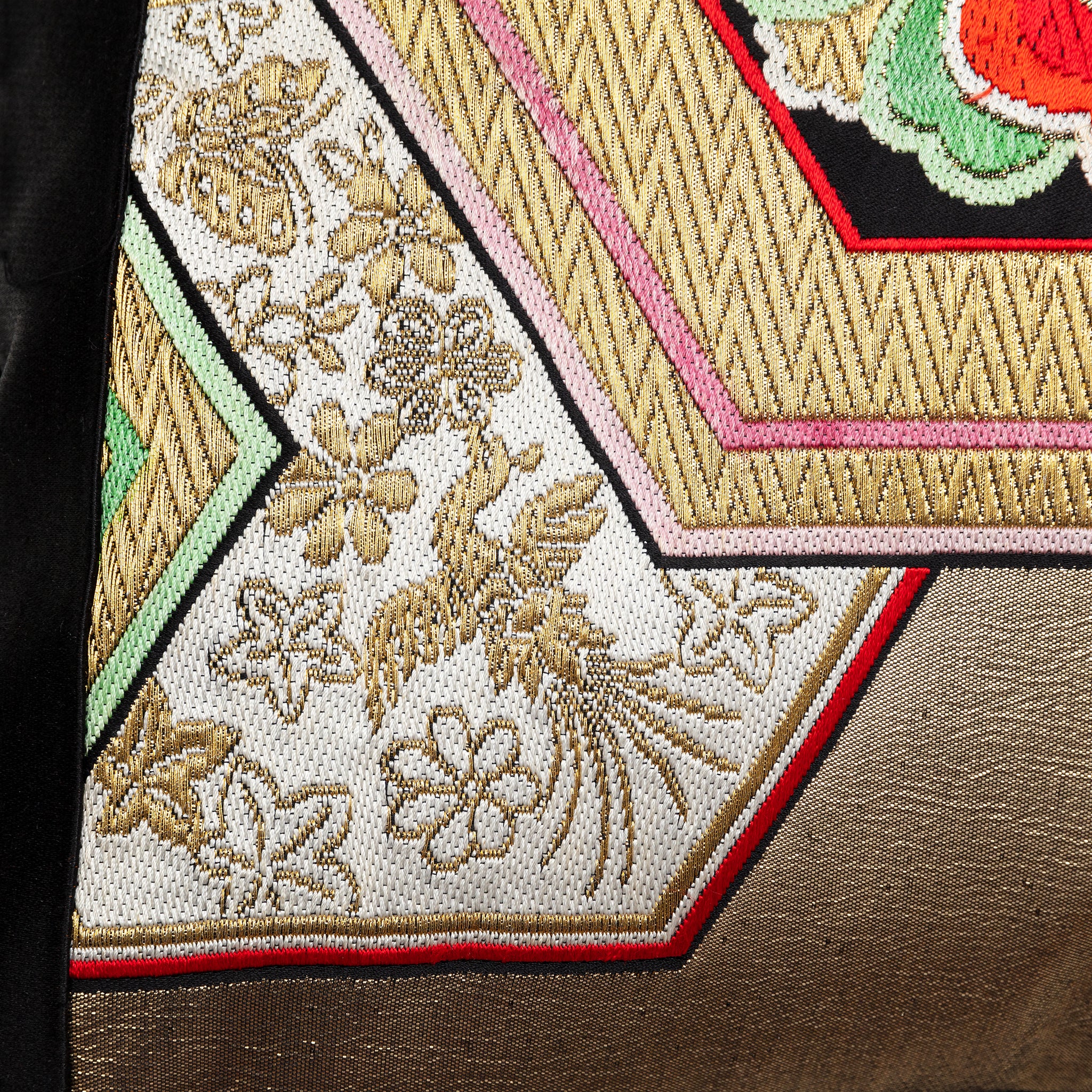 Close up of a phoenix motif in gold on a vintage obi cushion.