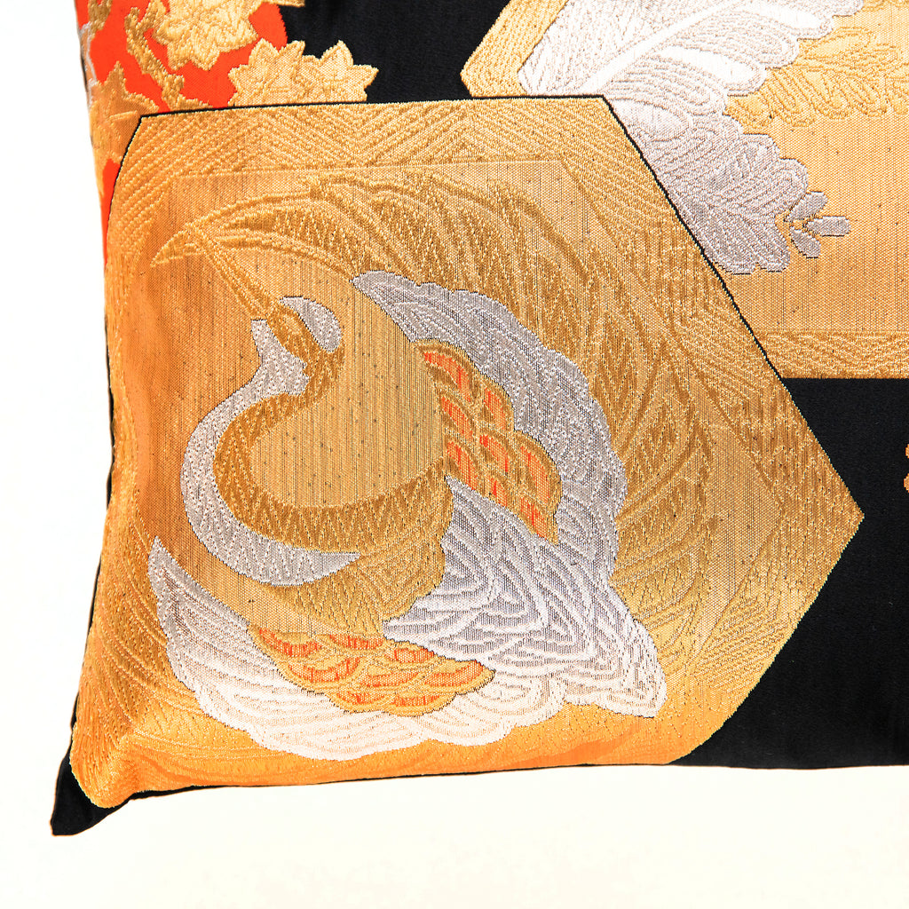 view of corner of black silk Japanese vintage obi pillow with gold and silver crane in fortune hexagon.