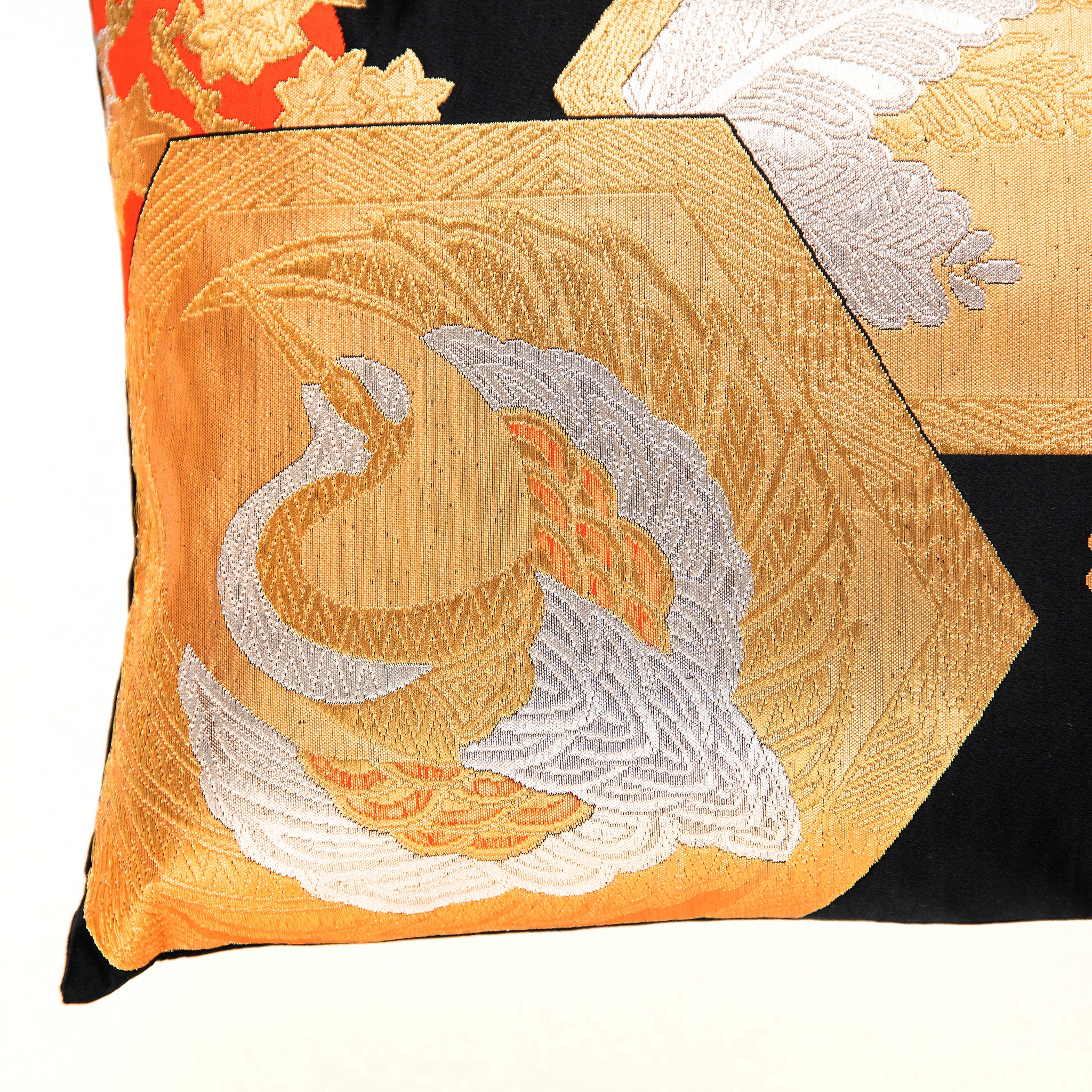 view of corner of black silk Japanese vintage obi pillow with gold and silver crane in fortune hexagon.