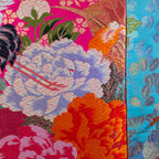 Close-up of the vibrant pink and blue embroidered crane detail on the vintage Uchikake silk fabric of the cushion.