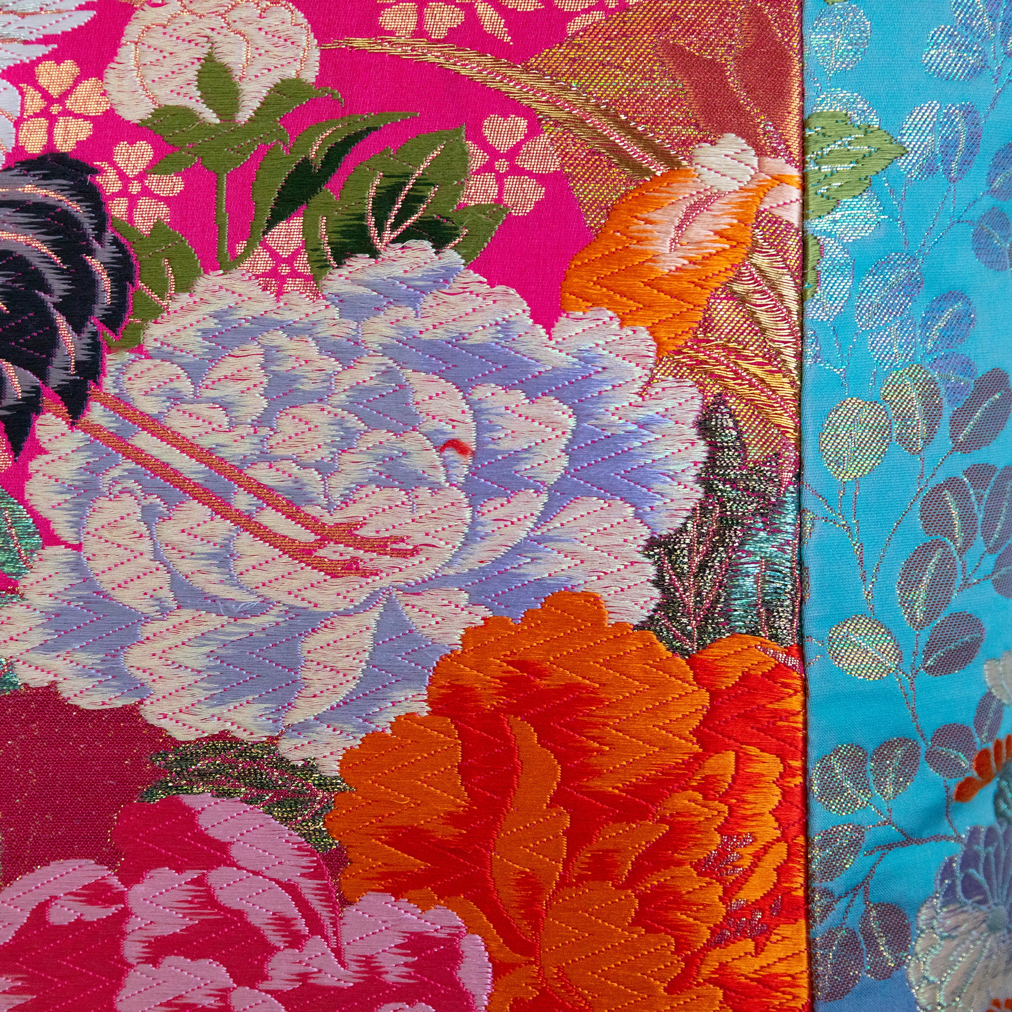 Close-up of the vibrant pink and blue embroidered crane detail on the vintage Uchikake silk fabric of the cushion.