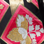 Close-up of embroidered black silk obi cushion with pink diamond and gold and silver paulownia motif