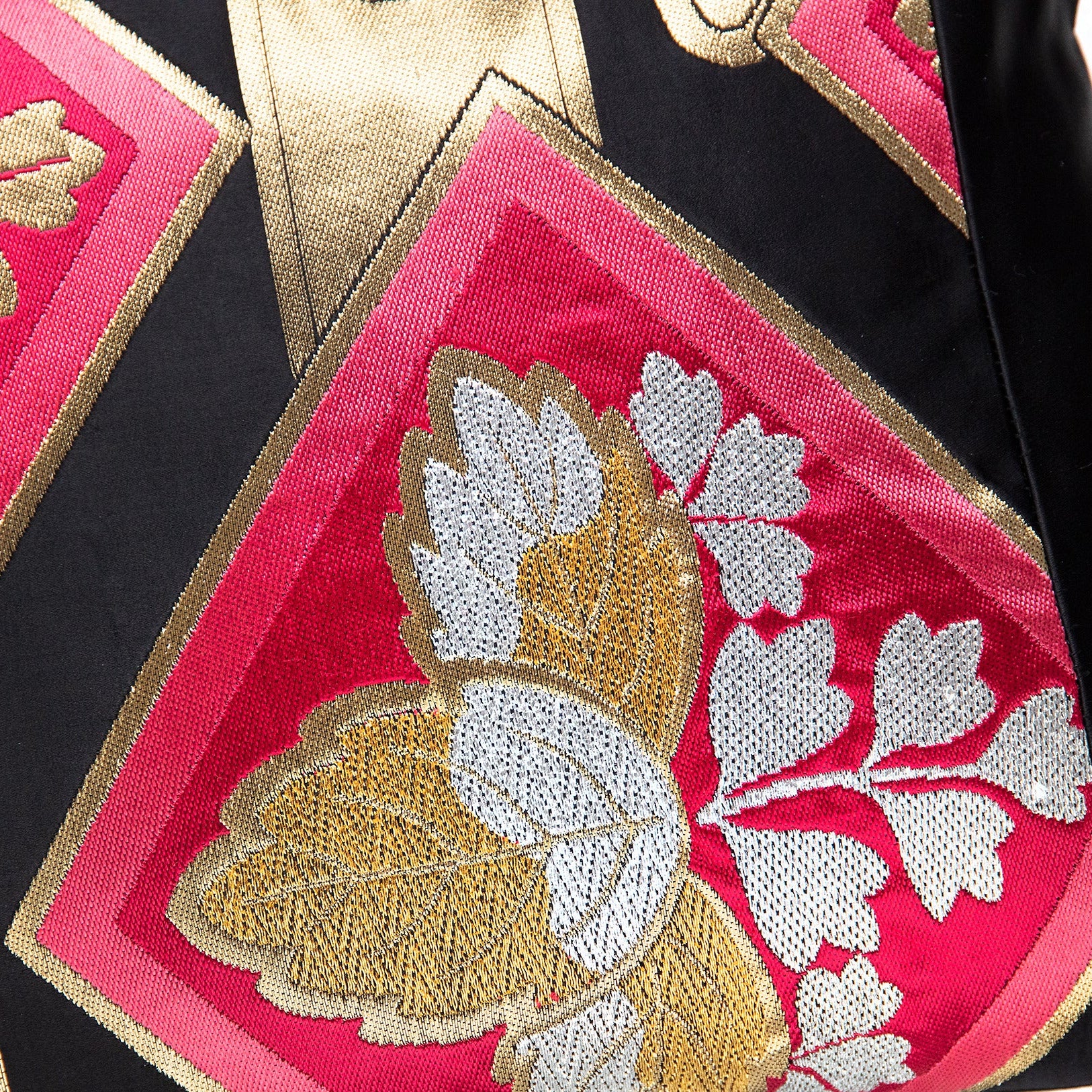 Close-up of embroidered black silk obi cushion with pink diamond and gold and silver paulownia motif