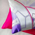 View of the corner of the purple and silver Japanese obi pillow and the pink pillow reverse below.