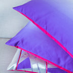View of three cushion corners, all made from one vintage Japanese silk obi in bright purple silk with bright pink backs.