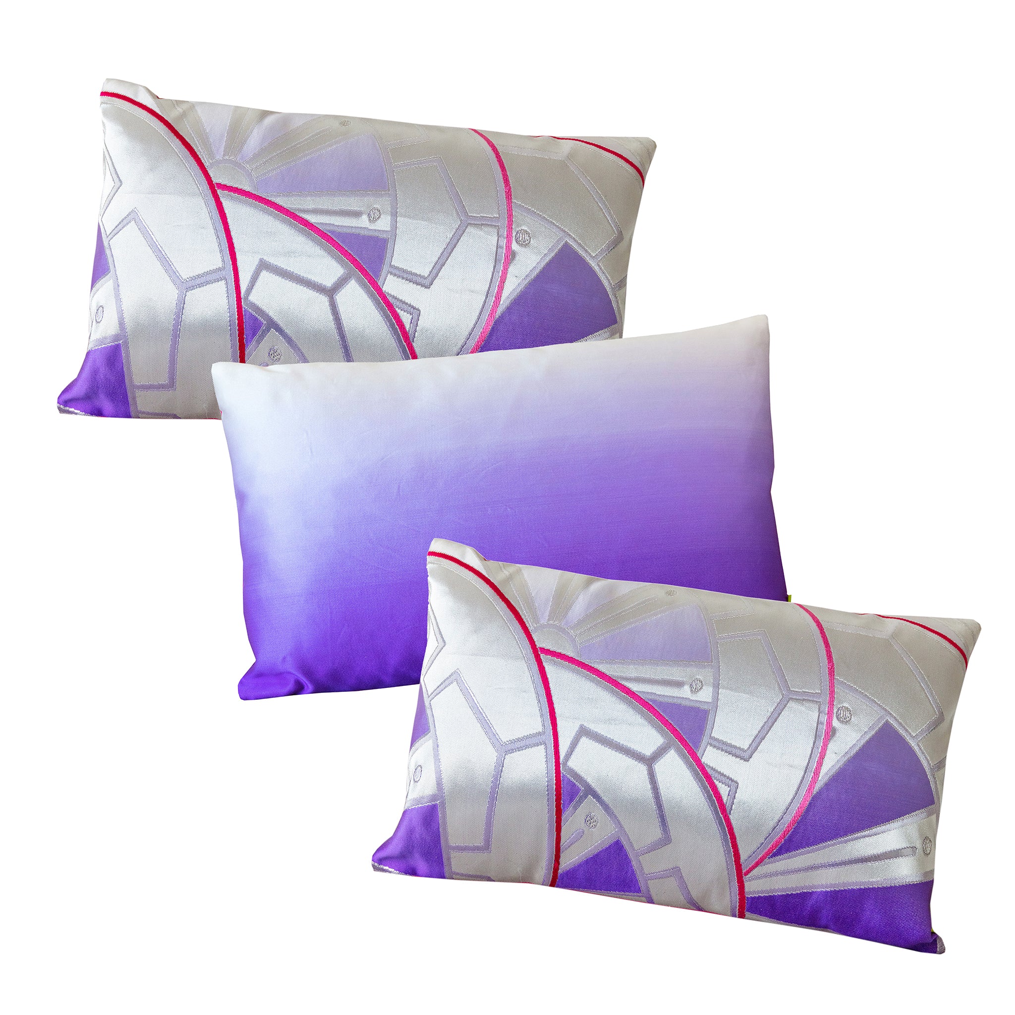 A set of three rectangular pillows with a purple ombre silk design featuring bright pink accents and a geometric Genji wheel pattern.