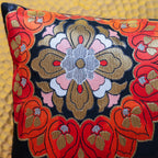 Detail of corner of black silk obi cushion with red, pink and gold floral motif.