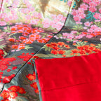 Close-up of vintage kimono-inspired embroidery details on the silk throw blanket's textured border and finishing stitches.