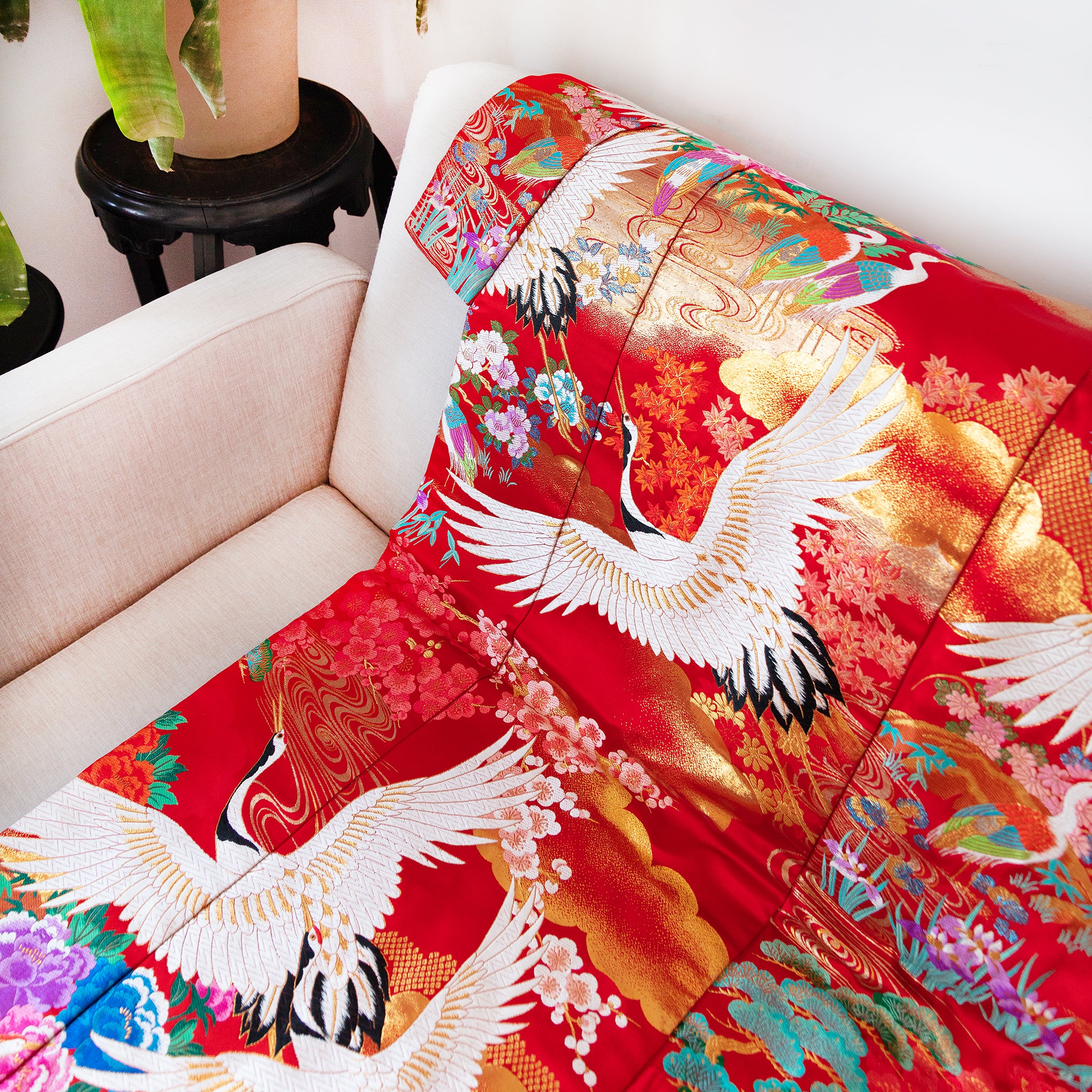 silk kimono throw in red and gold with white cranes on a sofa