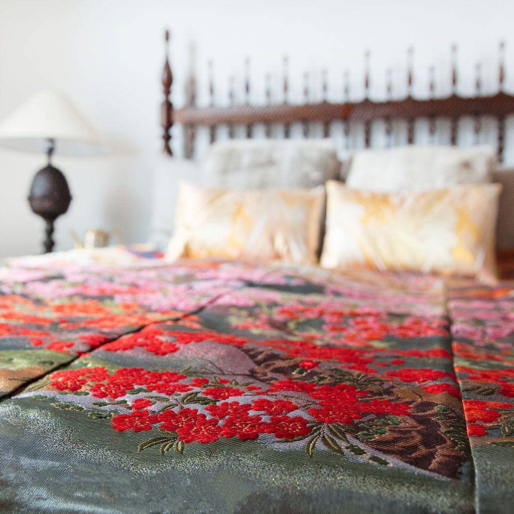 Close-up of the vintage floral embroidery and delicate silk weave on the corner of the kimono bedspread, highlighting