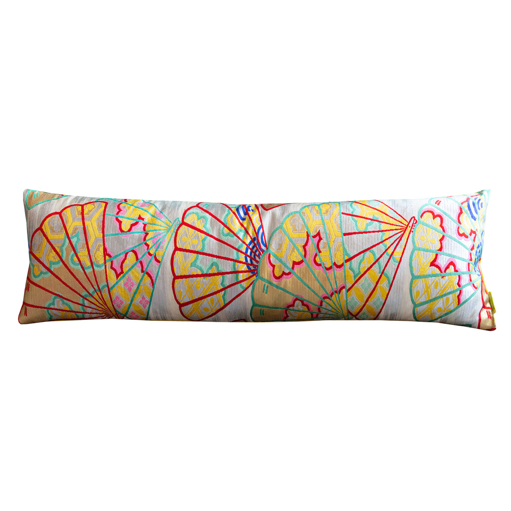 A bolster pillow with a vintage kimono silk design featuring yellow and multicolored fans on a silver background, and a yellow velvet reverse.