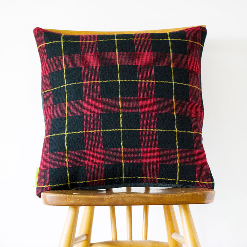 Close-up of grey wool tartan fabric showing intricate 1960s Gannex pattern and textured weave detail.
