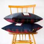 Close-up of grey tartan wool fabric showcasing the textured weave and subtle frayed edges of the Gannnex cushion cover.