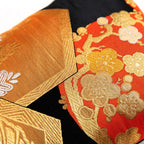 Detail of black, gold and orange silk obi pillow with blossom motif.