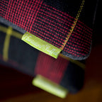 Close-up of navy tartan pattern detail on the wool cushion cover, showcasing textured fibers and precise weaving.