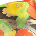 Yellow floral pattern on a vintage Japanese black silk obi cushion with green leaves and gold accents.