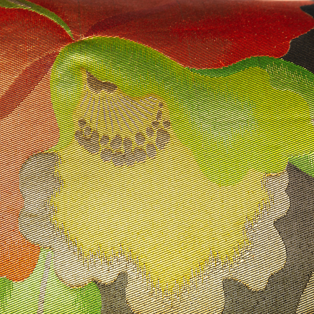 Close up of yellow and gold flower motif on a black and red silk Japanese obi pillow.