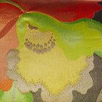 Close up of yellow and gold flower motif on a black and red silk Japanese obi pillow.